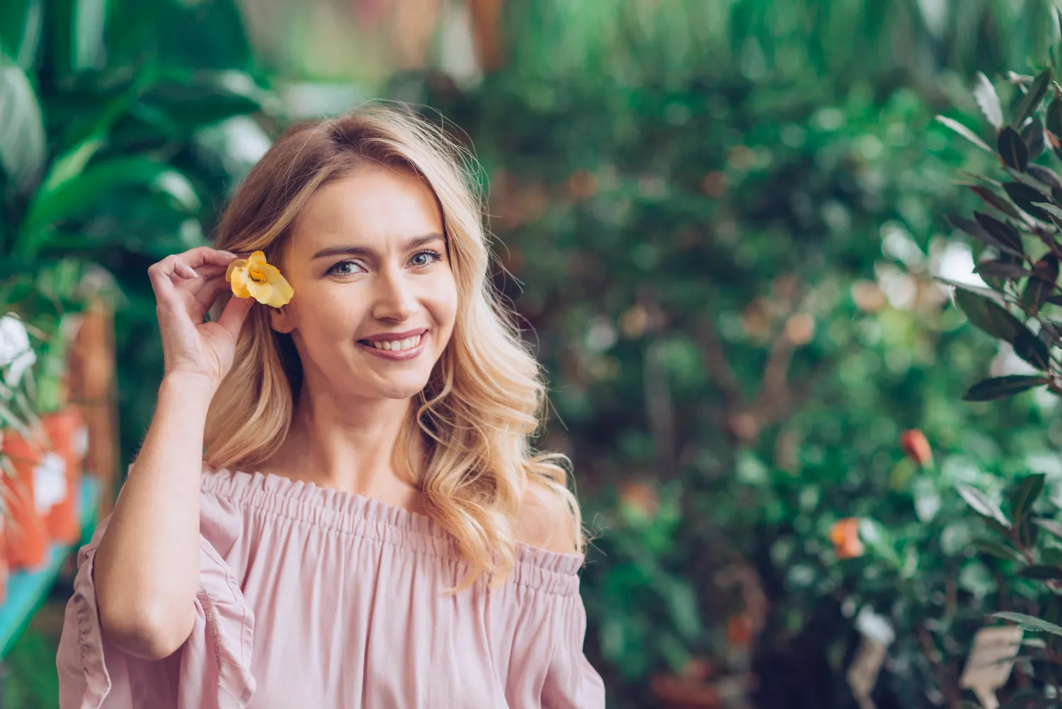 A smiling woman with a yellow flower behind her ear, featured on the Lakeway cosmetic dentistry website.