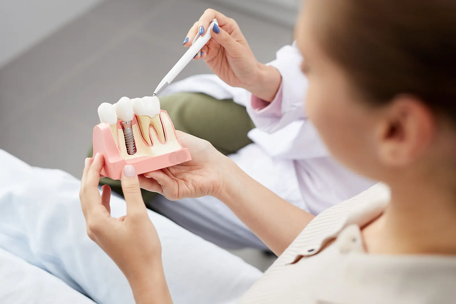 A dentist explaining how dental implants are placed in the jaw.